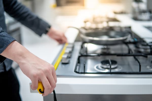 A person measuring a cooktop A person measuring a cooktop
